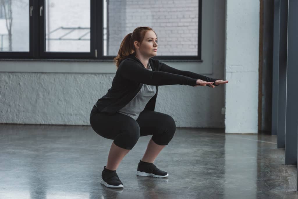 woman strengthening core by doing squats