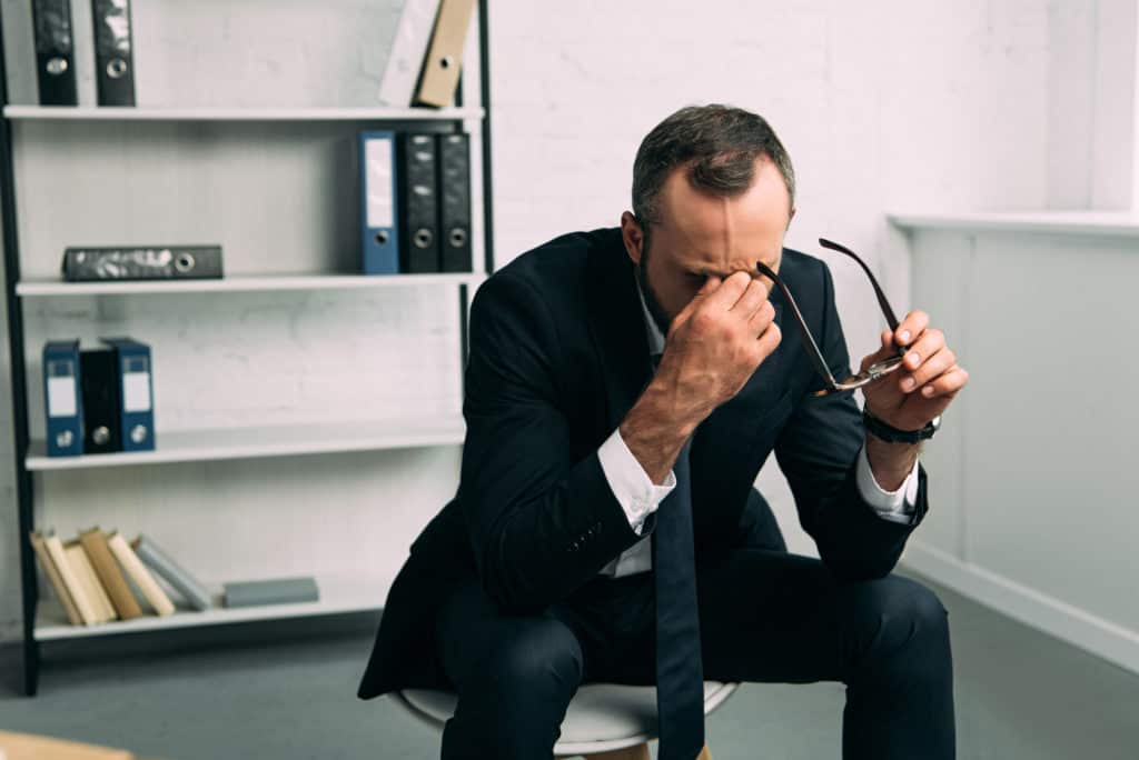 Man holding his head due to being very stressed