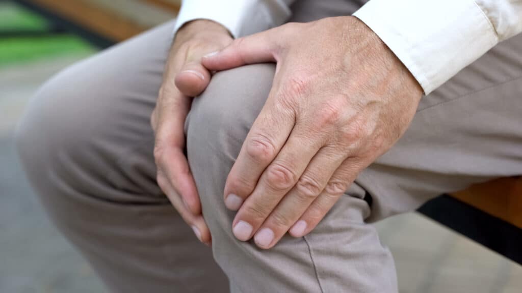 why knee pain should be treated quickly, man holding his knee