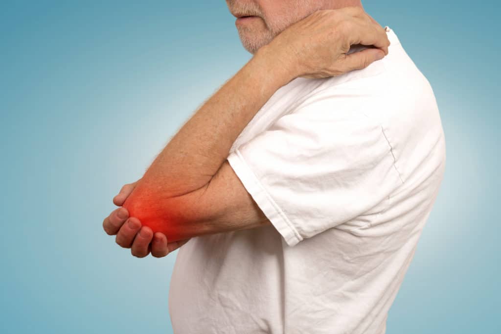 Old man suffering from arthritis in his elbow 
