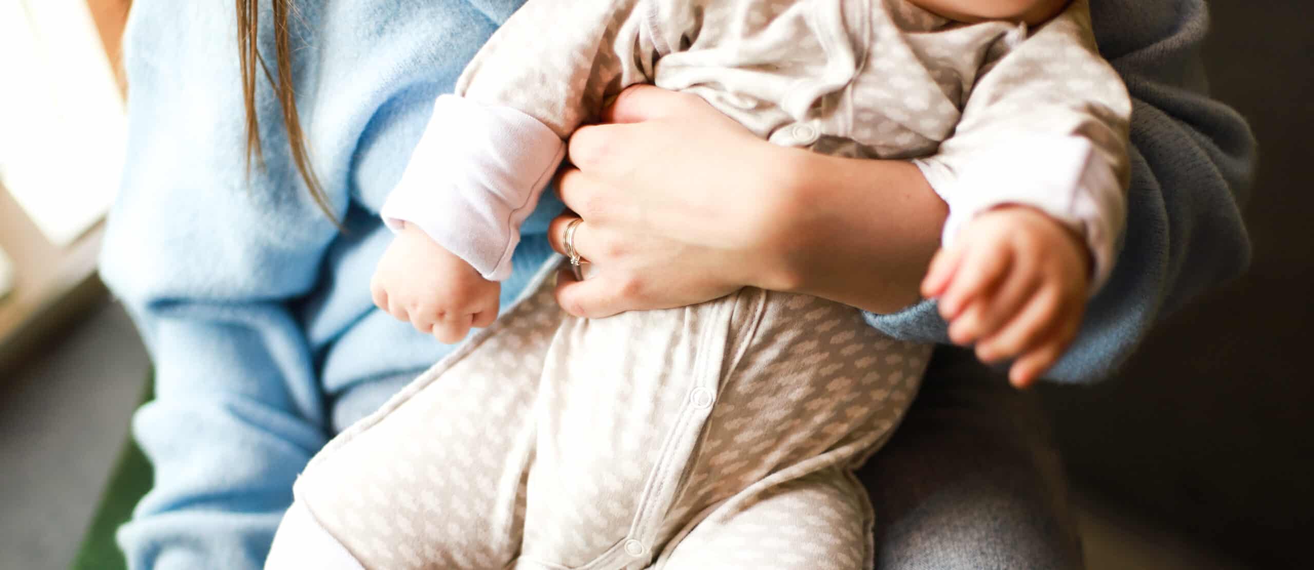 mom holding baby with Postpartum joint pain