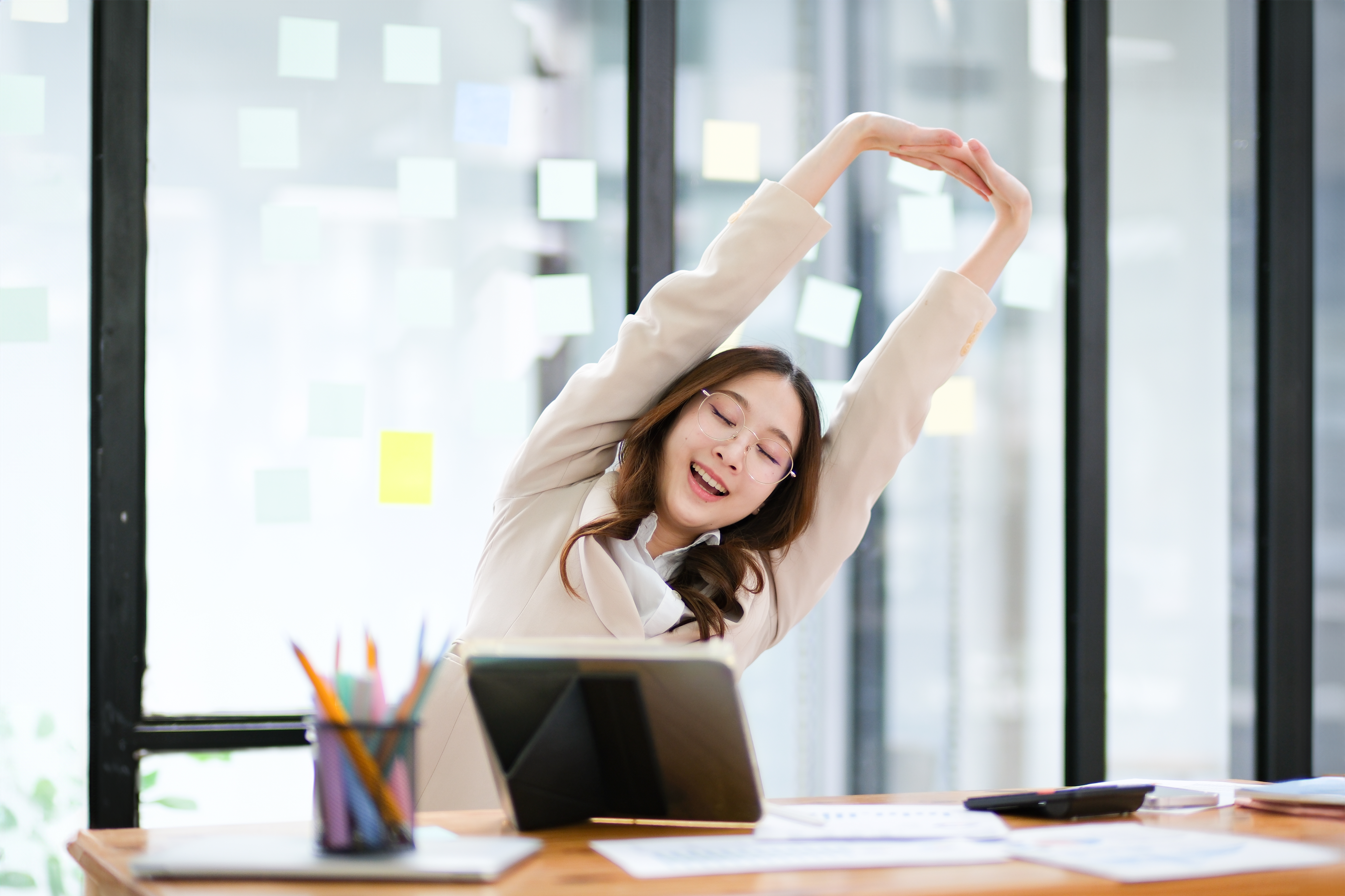 woman stretching at her desk to crack her back