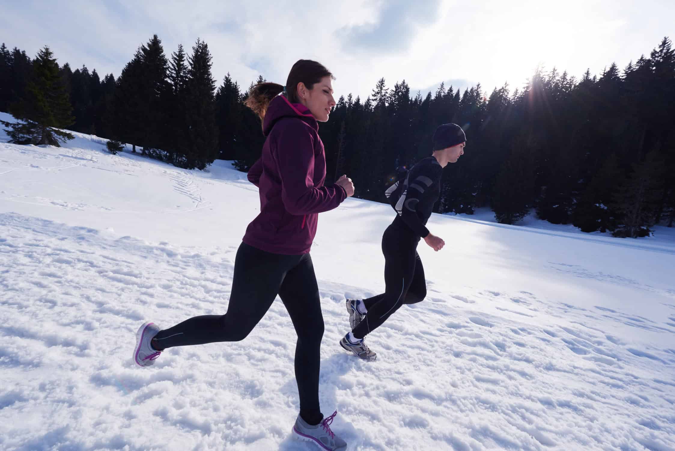 a man and woman running in snow