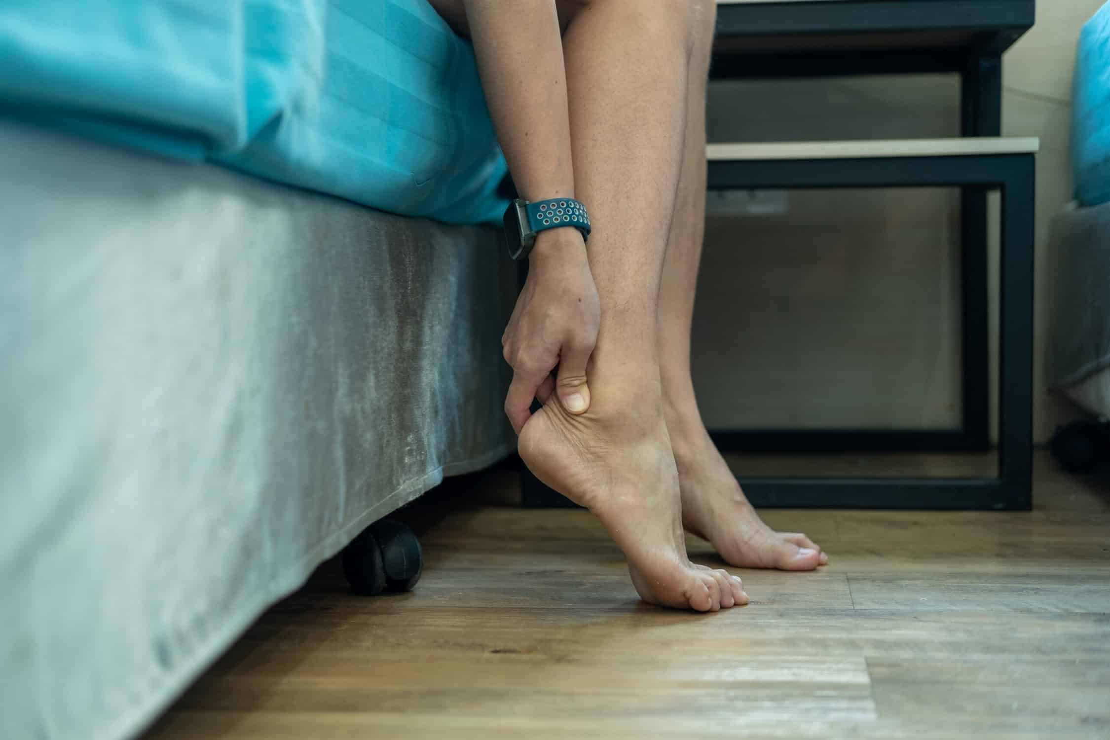 a person holding their foot with ankle arthritis