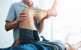 Physical therapist working with older adult patient on knee prehab exercises at Intecore Physical Therapy in Bremerton Washington