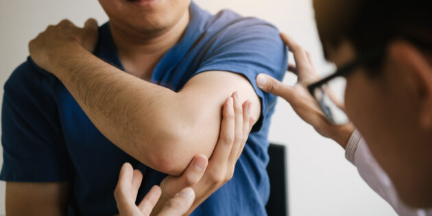 a person measuring the elbow of a man