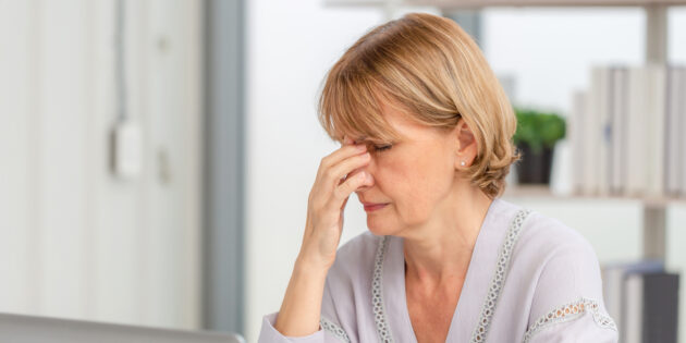 lady suffering from tension headache touching her head