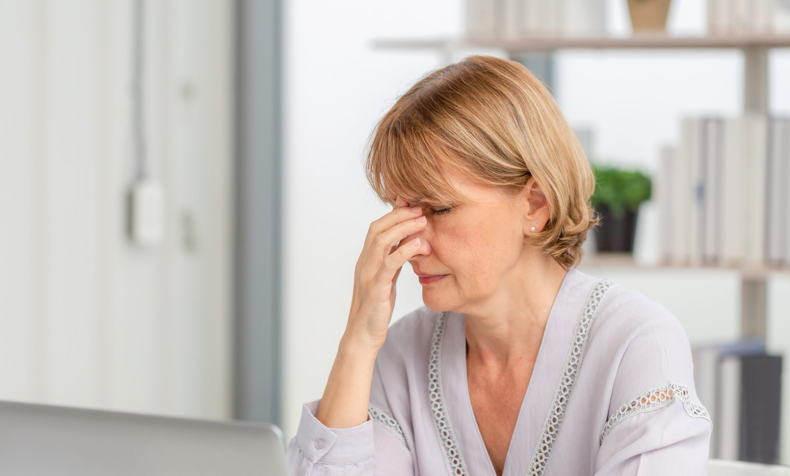 lady suffering from tension headache touching her head