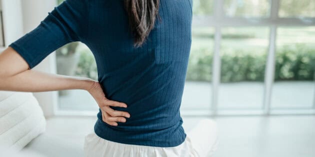 a woman sitting on the floor with her back on her hand